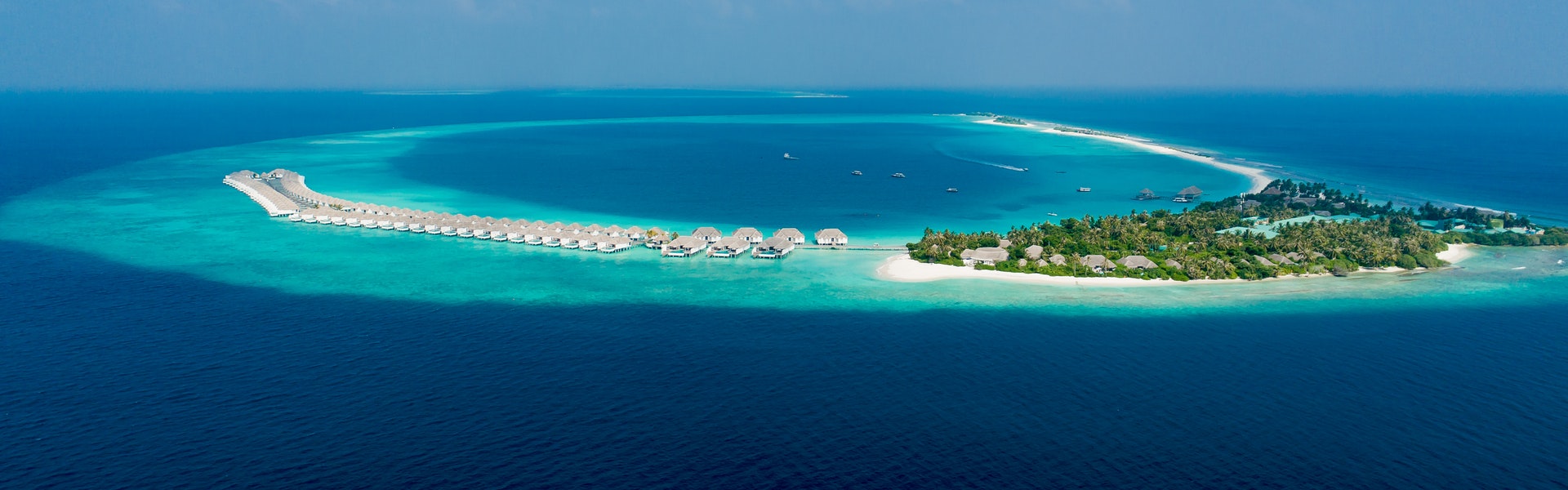 Aerial view of ocean resort with overwater bungalows and turquoise sea