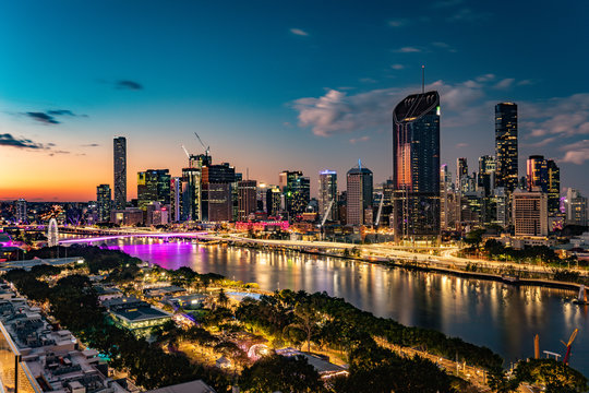 Brisbane city skyline at sunset with river and illuminated buildings
